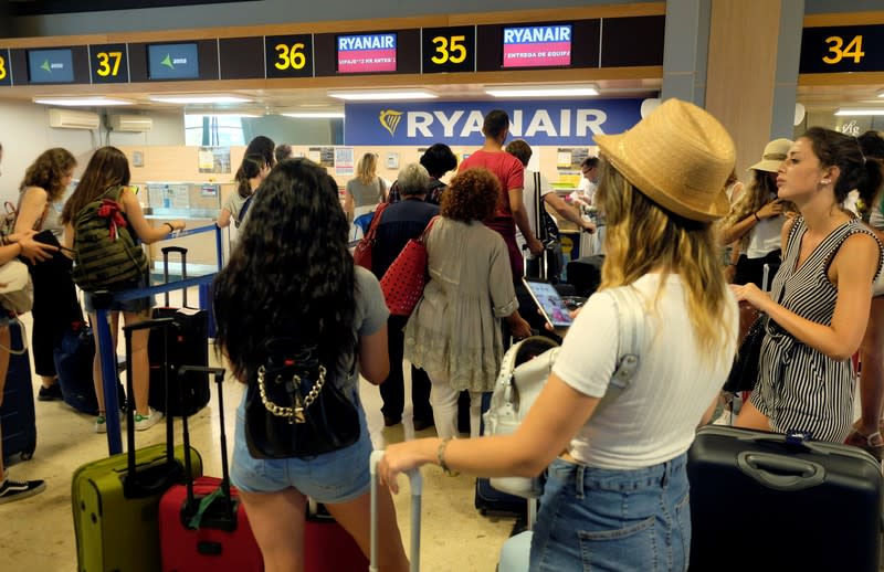 FILE PHOTO: Ryanair passengers line up to check in their luggage at the airport, during a protest on the second and last day of a cabin crew strike held in several European countries, in Valencia