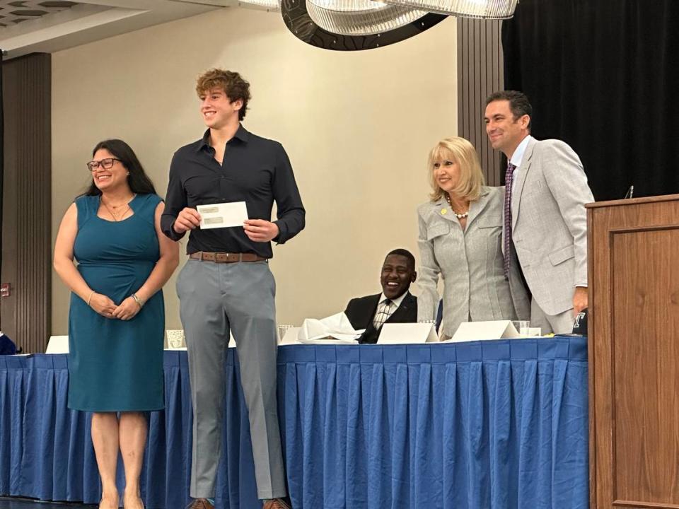 Miami Beach’s Caleb Berman (second from left) is presented with a $1,000 scholarship by Herff Jones Miami.