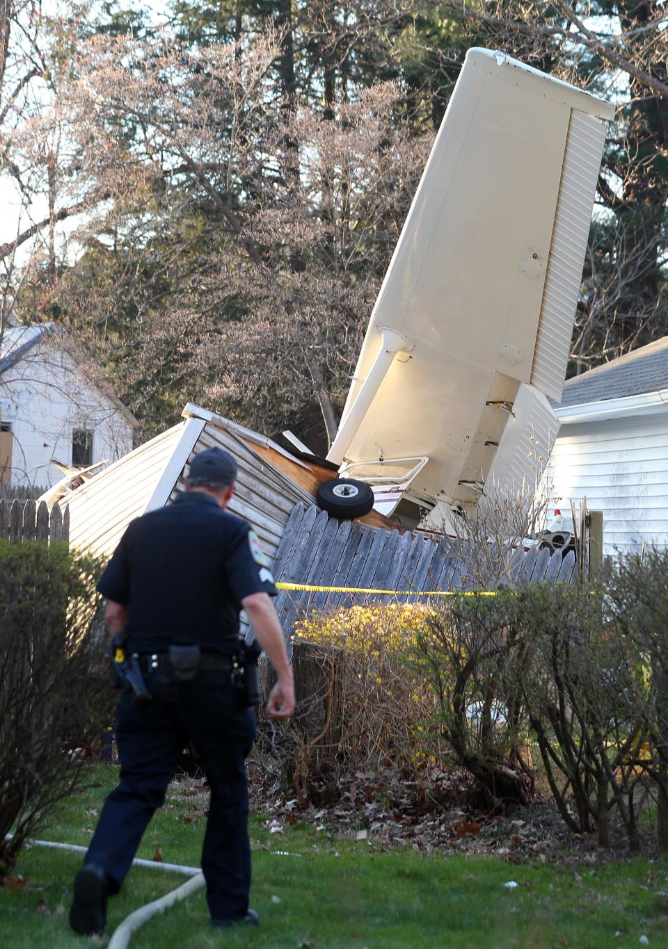 Danbury firefighters look over the scene of a single engine plane that crash behind a home at 159 Southern Blvd in Danbury April 10, 2023. The pilot and passenger walked away from the crash and were transported to Danbury Hospital with minor injuries. 