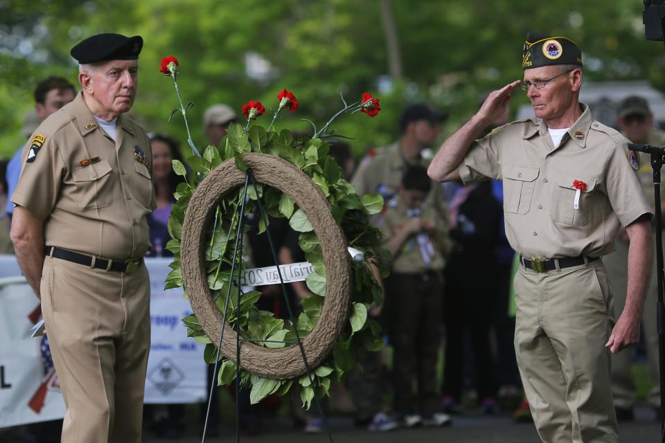 United States Army Vietnam War veteran Francis Cahill (L) looks on as U.S. Navy veteran Brian Keenan salutes during Memorial Day ceremonies at Cedar Grove Cemetery in Boston, Massachusetts May 26, 2014. (REUTERS/Brian Snyder)