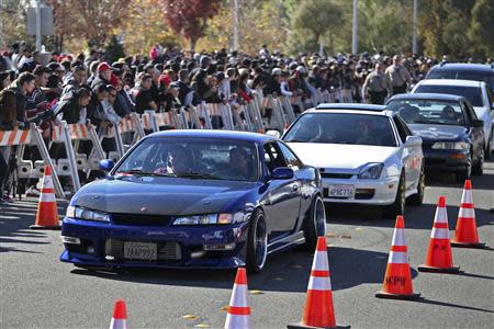 Vehicles are driven past a crowd attending an unofficial memorial event for "Fast & Furious" star Paul Walker in Santa Clarita, California December 8, 2013. REUTERS/Jonathan Alcorn