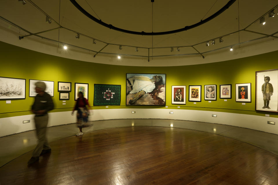 Visitors view an art exhibition at the Apartheid Museum in Johannesburg, South Africa, Wednesday, April 24, 2024. A selection of artworks which were produced during the country's apartheid era and ended up in foreign art collections are on display to mark 30 years since the country's transition to democracy in 1994. (AP Photo/Themba Hadebe)