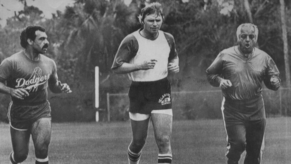 Tommy Lasorda runs with players Davey Lopes, left, and Bill Russell at spring training in Vero Beach, Fla., in 1981.