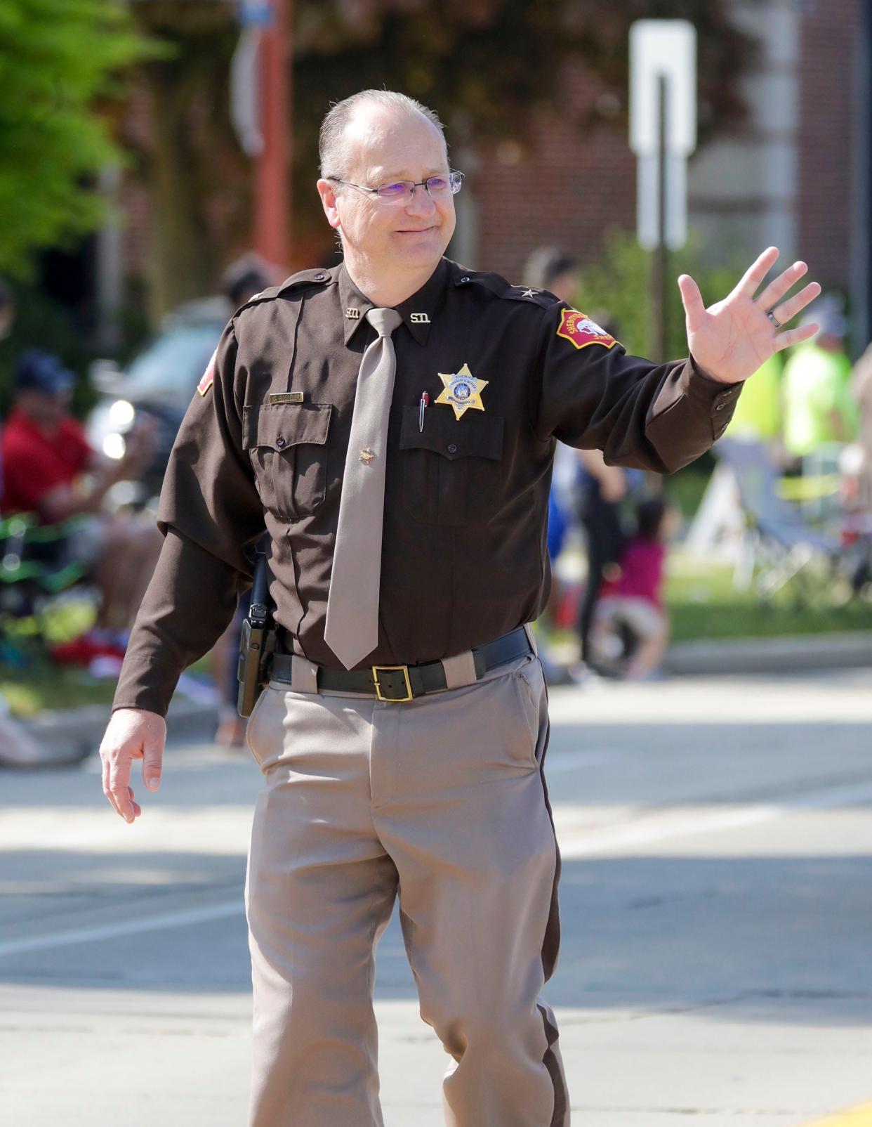 Sheboygan County Sheriff Cory L. Roeseler waves while marching in the Memorial Day parade, Monday, May 29, 2023, in Sheboygan, Wis.