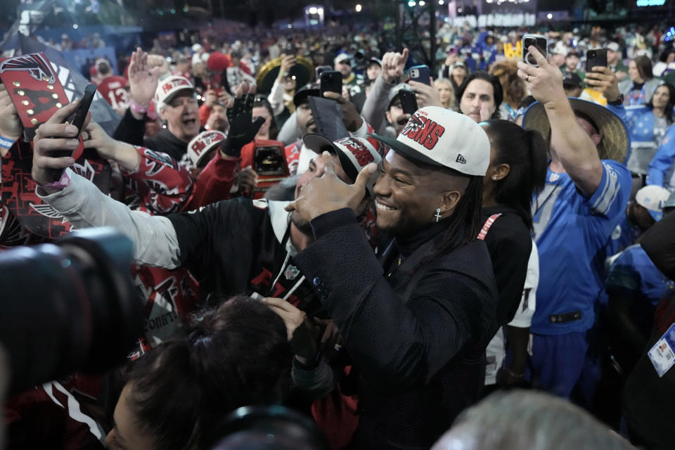 Texas running back Bijan Robinson poses with fans after being chosen by the Atlanta Falcons with the eighth overall pick during during the first round of the NFL football draft, Thursday, April 27, 2023, in Kansas City, Mo. (AP Photo/Charlie Riedel)