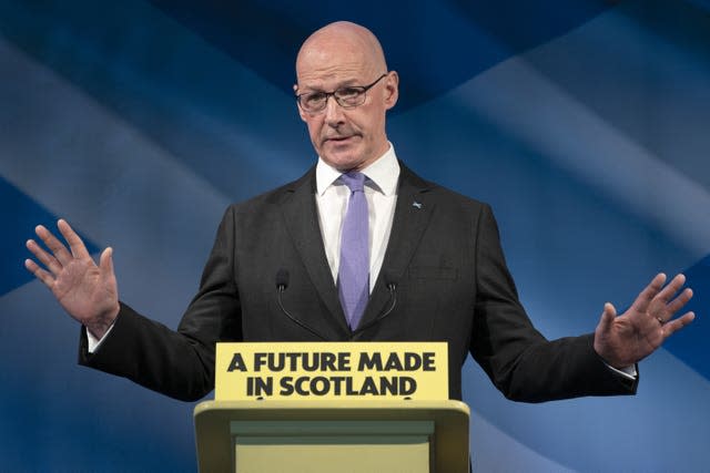 John Swinney speaking from behind a podium