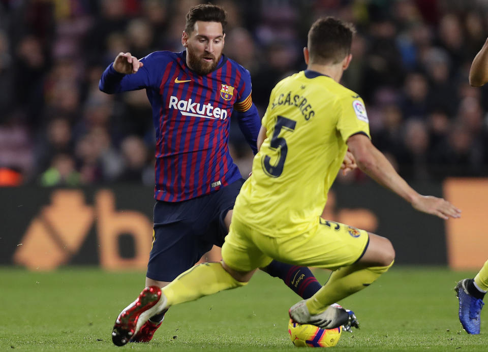 FC Barcelona's Lionel Messi, left, duels for the ball with Villarreal's Santiago Caseres during the Spanish La Liga soccer match between FC Barcelona and Villarreal at the Camp Nou stadium in Barcelona, Spain, Sunday, Dec. 2, 2018. (AP Photo/Manu Fernandez)