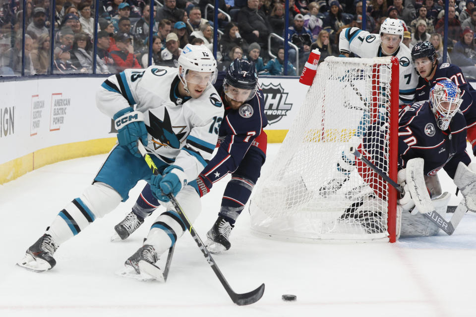 San Jose Sharks' Nick Bonino, left, carries the puck behind the net as Columbus Blue Jackets' Sean Kuraly defends during the first period of an NHL hockey game on Saturday, Jan. 21, 2023, in Columbus, Ohio. (AP Photo/Jay LaPrete)
