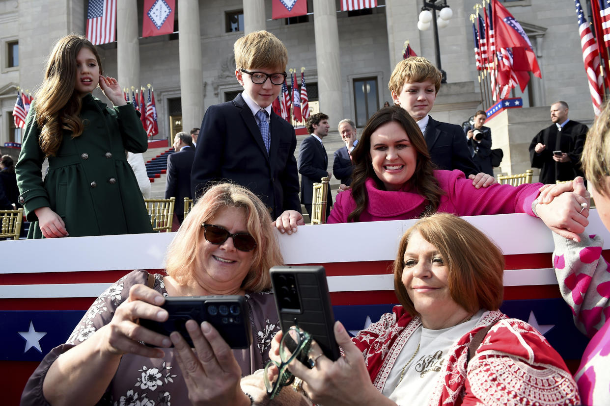 Arkansas Gov. Sarah Huckabee Sanders, flanked by her children Scarlett, Huck and George, poses for a picture with supporters after taking the oath of the office on the steps of the Arkansas Capitol Tuesday, Jan. 10, 2023, in Little Rock, Ark. (AP Photo/Will Newton)