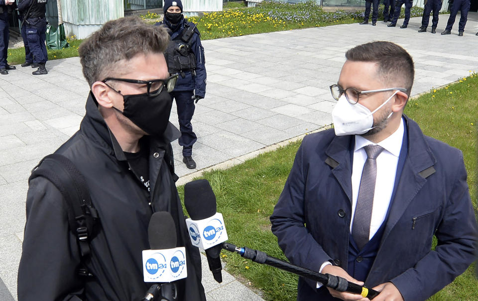 Judge Igor Tuleya, right, critical of the right-wing government's overhaul of the judiciary, speaks to reporters about his case outside Poland's Supreme Court in Warsaw, Poland, on Thursday, 22 April 2021. A disputed disciplinary body within Poland's Supreme Court is examining a motion that could result in the arrest of a judge who has become a symbol of the fight for an independent judiciary. The Disciplinary Chamber is due to decide whether to force Judge Igor Tuleya to answer to prosecutors about charges related to a ruling that went against the interests of the ruling Law and Justice party. (AP Photo/Czarek Sokolowski)