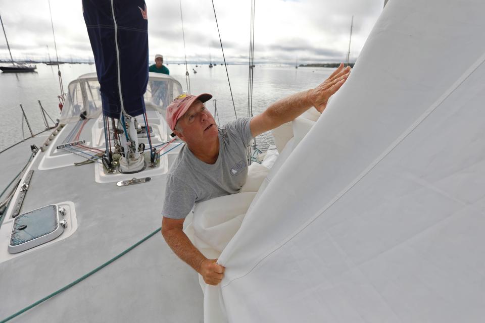 Scott Belliveau who is currently living in South Carolina had his friends Bob Warren, seen here removing the headsail, and Fran Grenon prepare his sailboat moored in Mattapoisett, MA harbor Tuesday for the possible Hurricane Lee making landfall at the end of the week.