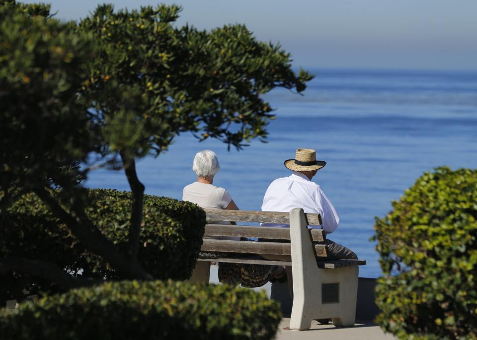 An elderly couple looks out at the ocean as they sit on a park bench in La Jolla, California November 13, 2013. REUTERS/Mike Blake (UNITED STATES - Tags: SOCIETY ENVIRONMENT)