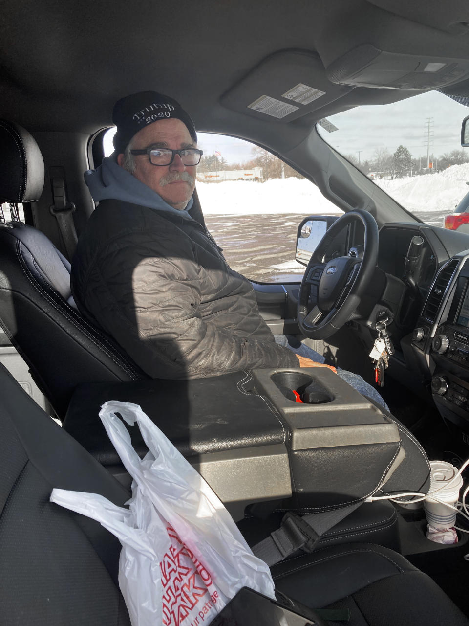 Larry Parsons, who bought a used pickup truck last year in part due to the high cost of new trucks, sits inside his Ford F-150 in Livonia, Mich., Tuesday, Feb. 16, 2021. A chain reaction touched off by the coronavirus pandemic has pushed new-vehicle prices to record highs and dramatically driven up the cost of used ones. (AP Photo/Mike Householder)