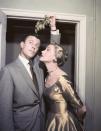<p>Anne Jeffreys joins Robert Sterling under a piece of mistletoe in 1954. The actress looked festive in a gold boatneck tea-length dress. </p>