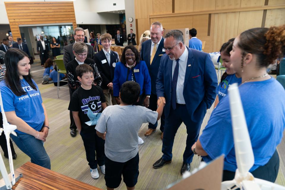 Miguel Cardona, U.S. secretary of education, shakes hands with Quincy Elementary students at TCALC  during a September event.