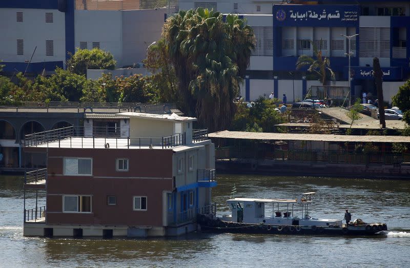 Government's boat pushes a houseboat on the River Nile in front of Imbaba Police Station in Cairo