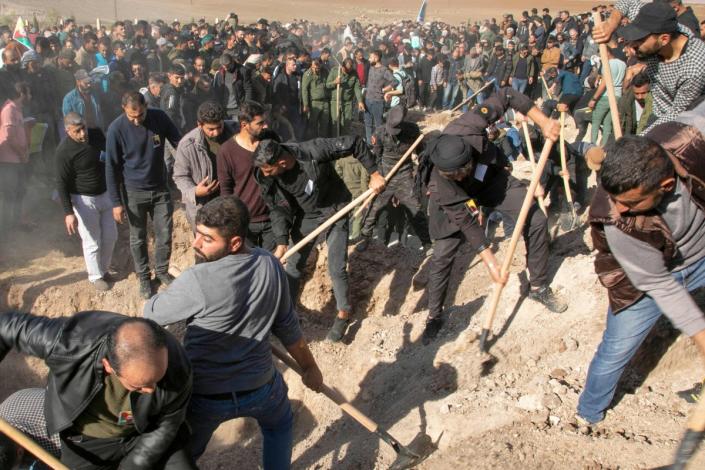 Syrian Kurds dig the graves of 11 people killed in Turkish air strikes (AFP via Getty Images)