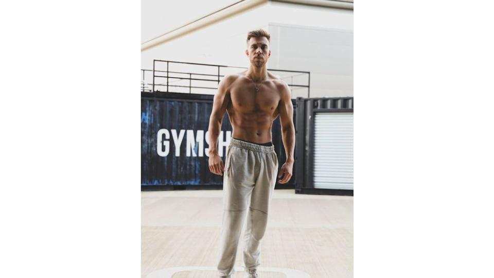 A shirtless man in grey sweatpants