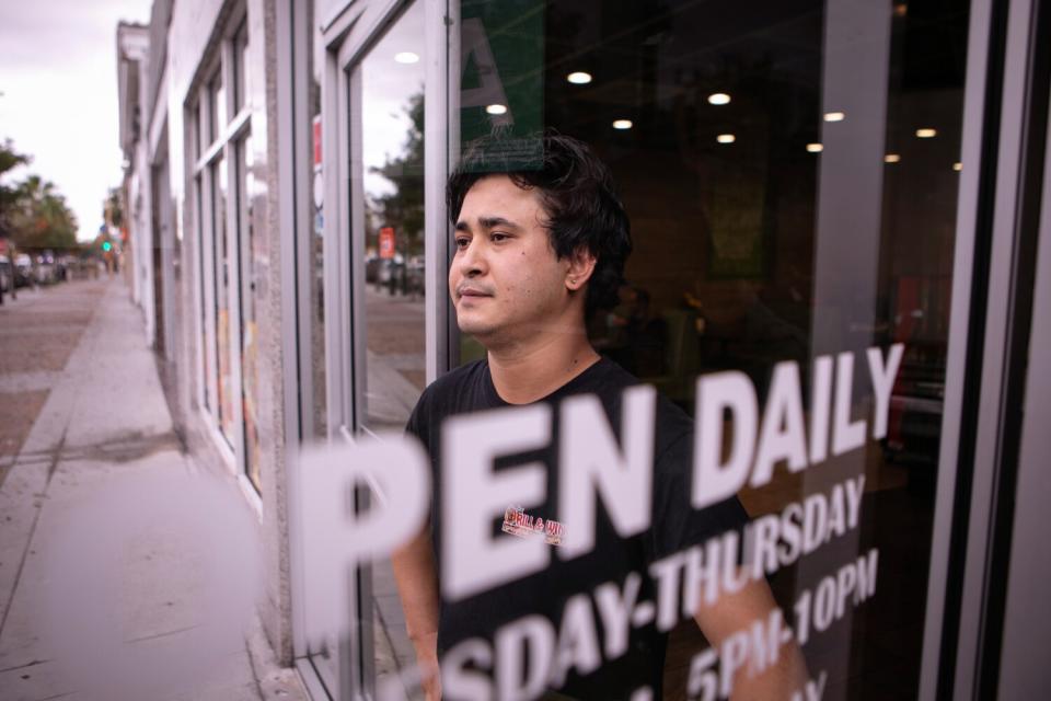 A man stands at the doorway of a restaurant