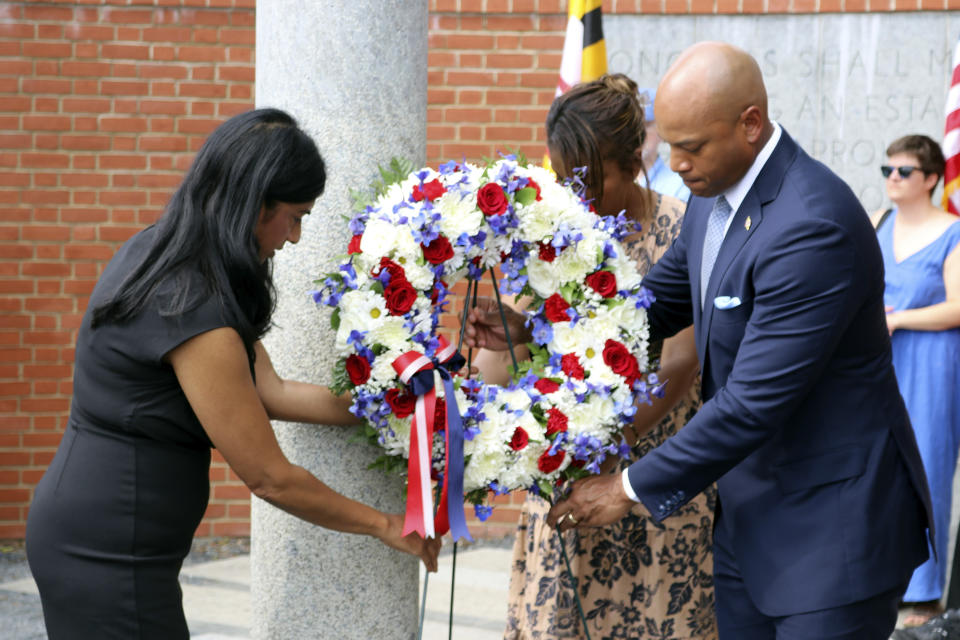 Maryland Gov. Wes Moore, right, first lady Dawn Moore, rear center, and Lt. Gov. Aruna Miller, left, place a wreath by one of five pillars at the Guardians of the First Amendment Memorial on Wednesday, June 28, 2023 in Annapolis, Md., on the fifth anniversary of the attack on the Capital Gazette newsroom that killed five people. By (AP Photo/Brian Witte)
