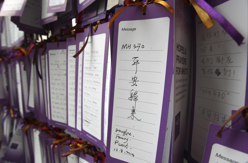 A message card reading "MH370 comes back safely" is tied up for passengers aboard a missing Malaysia Airlines plane, outside a shopping mall in Kuala Lumpur, Malaysia, Friday, March 14, 2014. A U.S. official said that the missing Malaysia Airlines flight MH370 pinged a satellite for four hours after it went missing, indicating that it may have stayed in the air long after its last contact with the ground. Malaysian authorities are widening their search westward, toward India, as a result. (AP Photo/Lai Seng Sin)