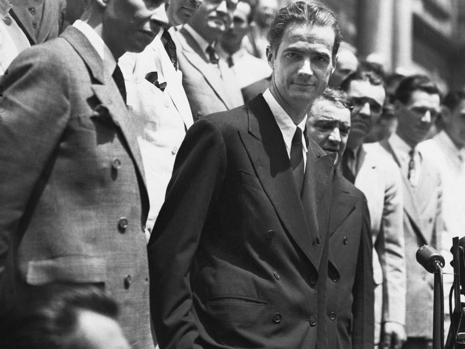 A faint smile lifts the corners of his lips as Howard Hughes takes New York's tumultuous reception in stride.