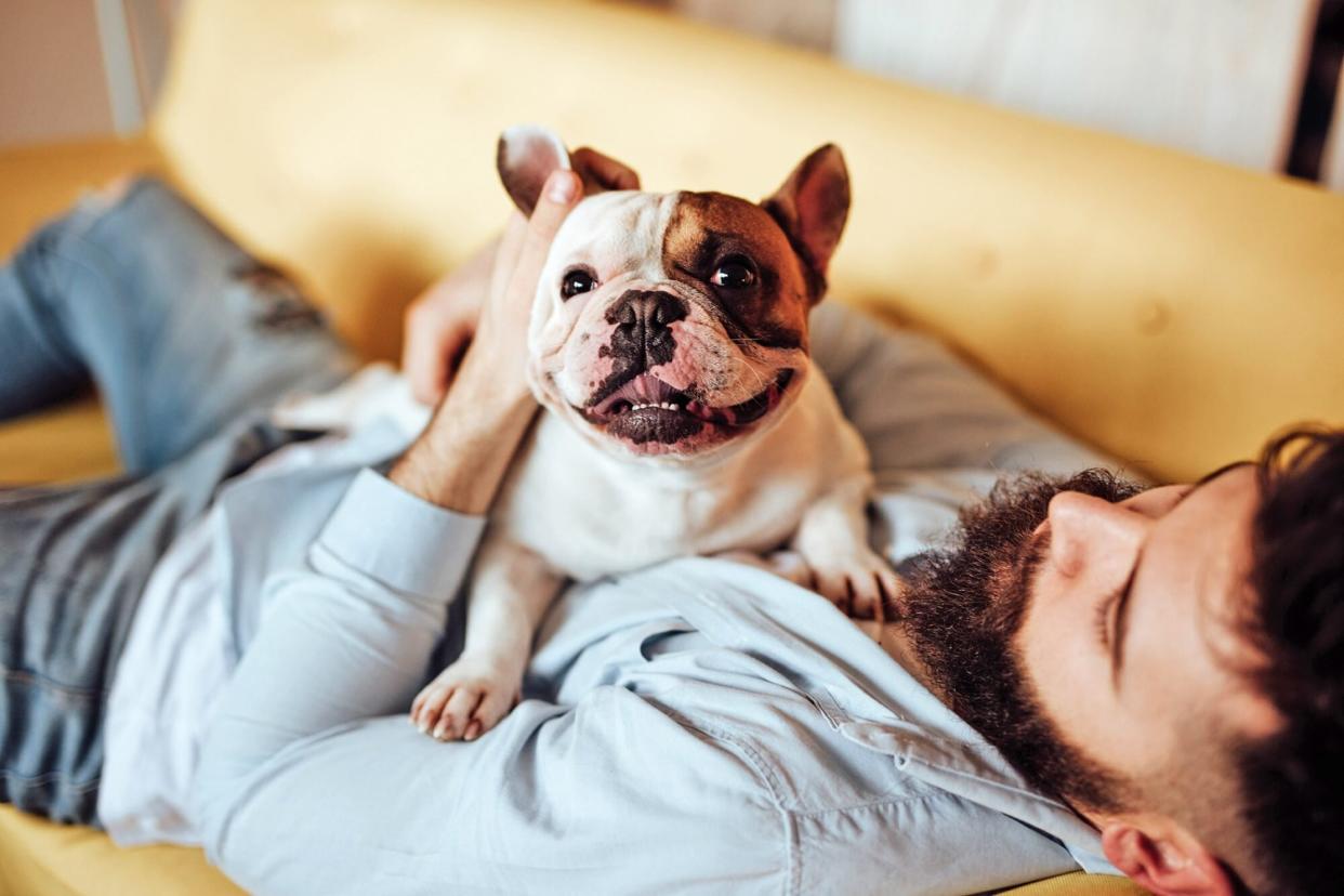 man embracing his dog on the couch