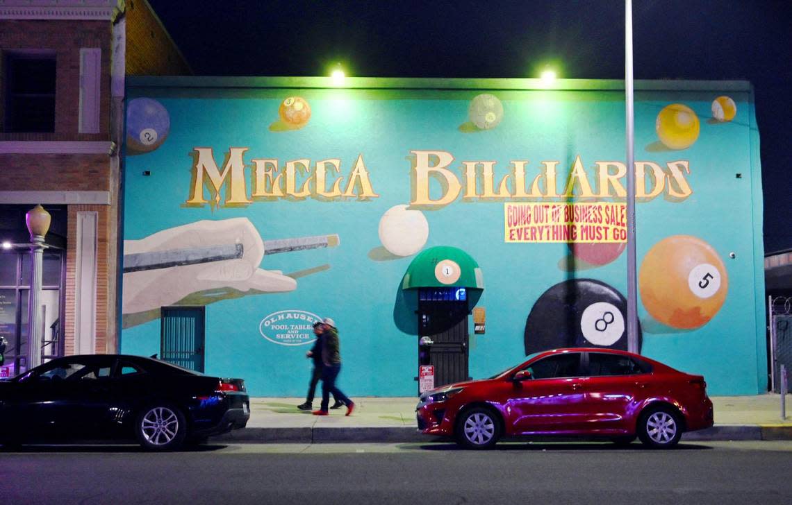 Mecca Billiards is seen at night on Fulton Street in downtown Fresno’s Brewery District, Friday, Feb. 10, 2023. Nanette Stockle, who operated Mecca Billiards with her husband until his death of ALS in February, is selling everything from the store in preparation to lease the building. The mural will remain. ERIC PAUL ZAMORA/ezamora@fresnobee.com