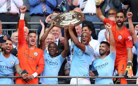 Fernandinho of Manchester City and Vincent Kompany of Manchester City lift the FA Community Shield Trophy - Credit: Getty Images