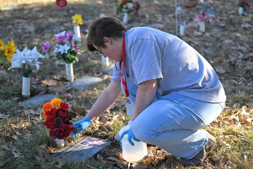 Laura Keyworth, Wayside’s pet memorial services manager, removes leaves before cleaning a headstone for a cockatiel.