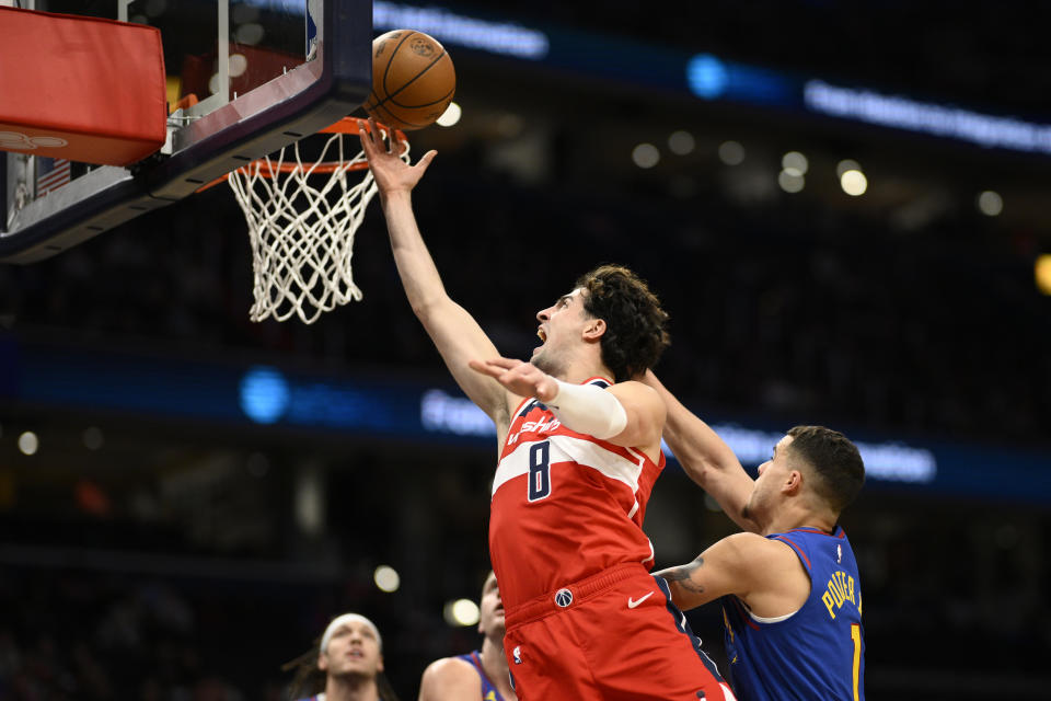 Washington Wizards forward Deni Avdija (8) goes to the basket against Denver Nuggets forward Michael Porter Jr. during the first half of an NBA basketball game, Sunday, Jan. 21, 2024, in Washington. (AP Photo/Nick Wass)