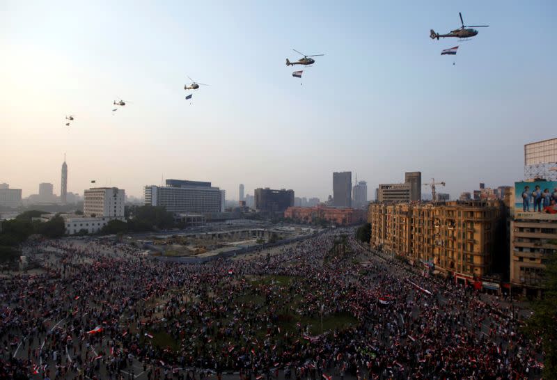 FILE PHOTO: Military helicopters are seen flying over while people gather at Tahrir Square in Cairo