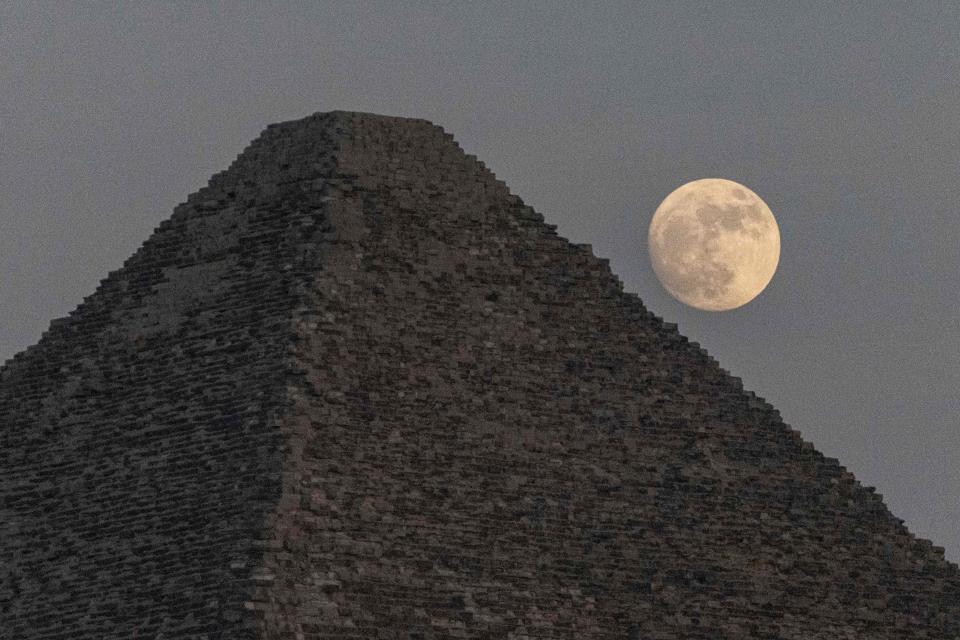 The waxing gibbous moon rises over the Great Pyramid of Khufu (Cheops) at the Giza Pyramids necropolis on the southwestern outskirts of the Egyptian capital on July 12, 2022 a day ahead of the July "buck supermoon". 