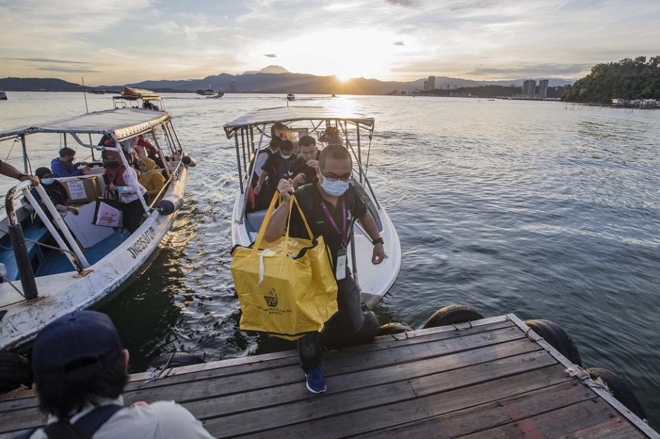 Election Commission personnel arrive at a polling station for the Sabah state election in SK Pulau Gaya September 26, 2020. — Picture by Firdaus Latif