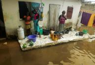 Residents stand at the door of their house, in a flooded courtyard, after heavy rains in Yeumbeul district on the outskirts of Dakar