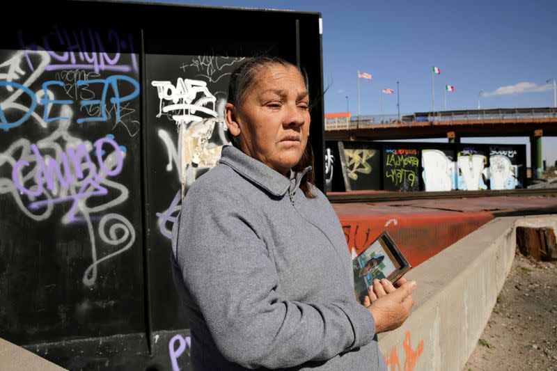 Guadalupe sits near the border fence between Mexico and U.S. where her son was shot in Ciudad Juarez