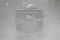 A jeepney transports pigs along a road covered with volcanic ash beside Taal volcano in Agoncillo, Batangas province, southern Philippines on Saturday Jan. 18, 2020. Local authorities have allowed some residents to return to their homes for a few hours in the morning to retrieve belongings and feed their pets or farm animals. The Taal volcano near the Philippine capital emitted more ash clouds Saturday, posing the threat of another eruption. (AP Photo/Aaron Favila)