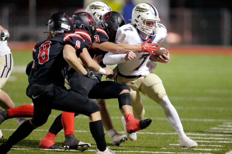 Heritage Hall's Andy Bass runs as Mason Mittasch of Verdigris tries to bring him down during a high school football semifinal playoff game between Heritage Hall and Verdigris in Prague, Okla., Friday, Nov. 25, 2022.