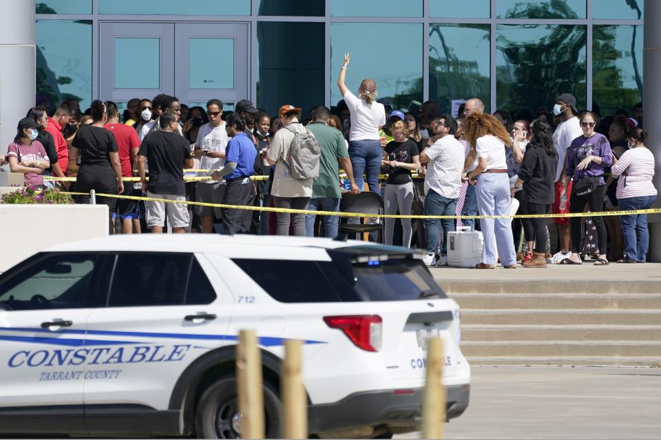 Families are addressed by an unidentified person at center, as they wait to be reunited with their children outside the school. Source: AP