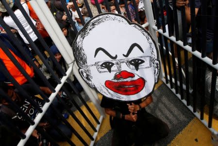 FILE PHOTO: A student activist holds up a placard of Fahmi Reza's caricature of Najib Razak during a protest to call for the arrest of