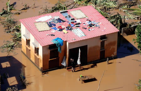 A man waves near his flooded house after Cyclone Idai in Buzi district outside Beira, Mozambique, March 22, 2019. REUTERS/Siphiwe Sibeko