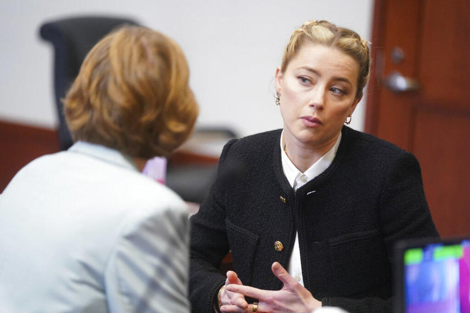 Actor Amber Heard talks to her attorneys in the courtroom at the Fairfax County Circuit Courthouse in Fairfax, Va., Thursday, May 19, 2022. / Credit: Shaw Thew / AP