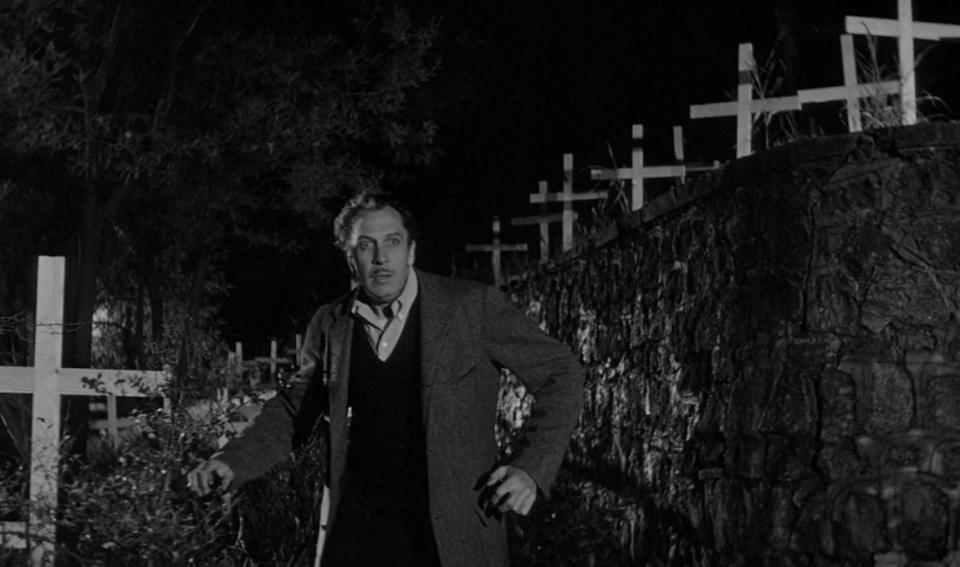 Vincent Price looking terrified in a graveyard full of crosses in the vampire film The Last Man on Earth.