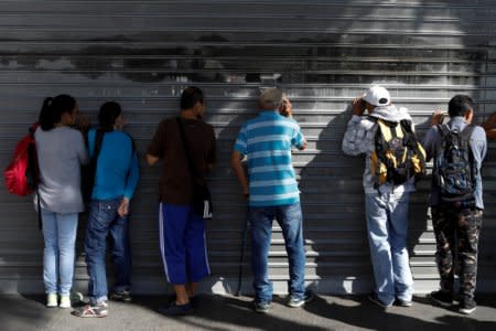 FILE PHOTO - People crowd at the gates of a supermarket as they wait to buy food in Caracas, Venezuela January 6, 2018. REUTERS/Marco Bello