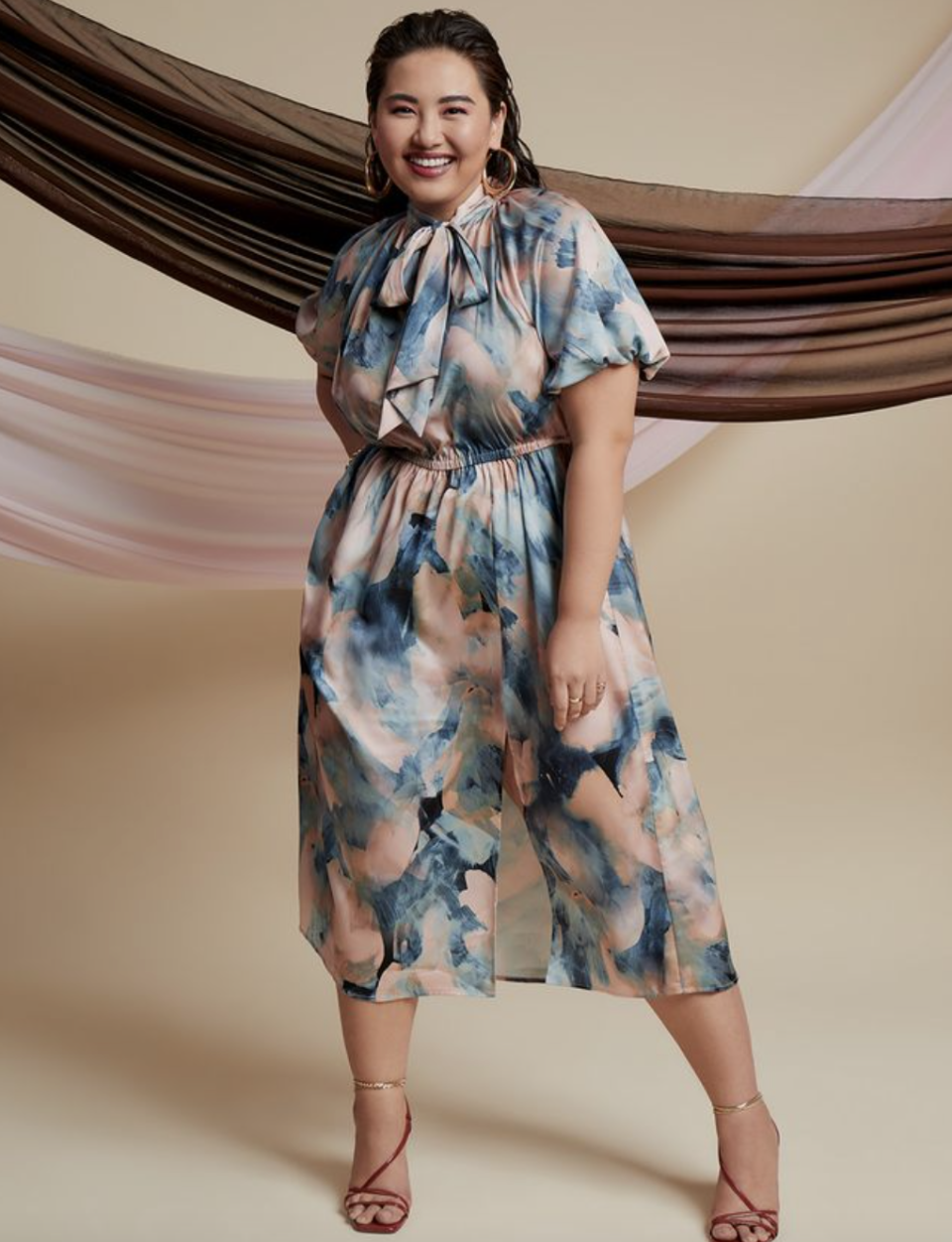 plus size asian model posing in floral midi dress and strappy heels