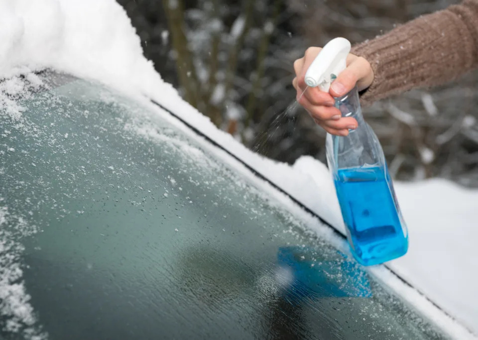Person spraying car windscreen. (Getty Images)
