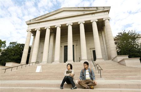 A couple from Japan sits on the steps of the National Gallery of Art, which they did not realize, is closed in Washington October 1, 2013. REUTERS/Kevin Lamarque