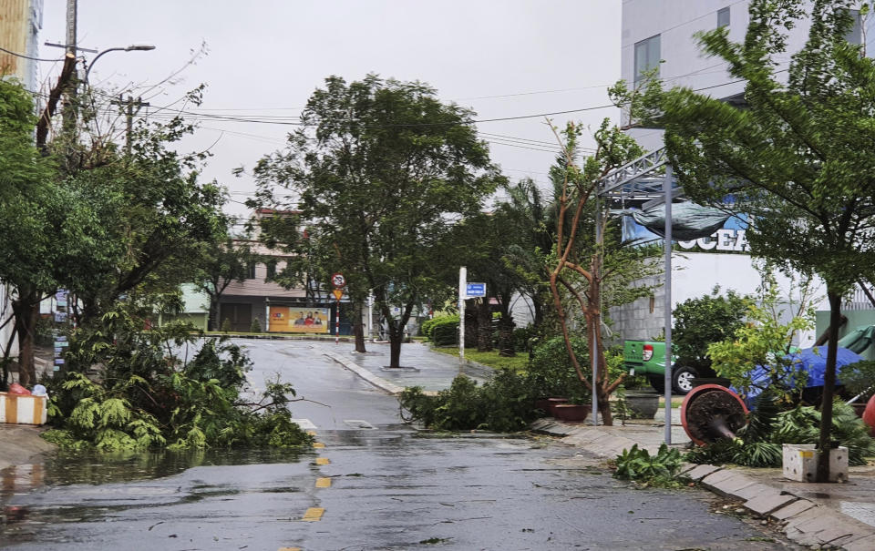 Broken tree branches caused by strong winds from typhoon Molave lie on a deserted street in Da Nang, Vietnam Wednesday, Oct. 28, 2020. Typhoon Malove sank a few fishing boats as it approached Vietnam's south central coast on Wednesday morning. (Vo Van Dung/VNA via AP)