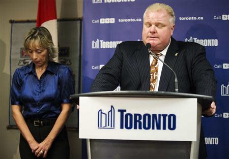 Toronto Mayor Rob Ford speaks at a news conference with his wife Renata (L) at City Hall in Toronto, November 14, 2013. REUTERS/Mark Blinch