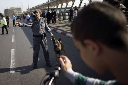 An Israeli police officer gestures at the scene of a stabbing in Tel Aviv November 10, 2014. REUTERS/Finbarr O'Reilly